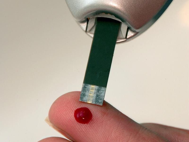 Bei einer Diabetikerin wird an einem Tropfen Blut mit einem Blutzuckermessgerät der Blutzuckerwert gemessen. Foto: Gero Breloer/Archiv