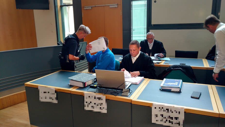Einer der vier Angeklagten im Mordprozess nimmt im Saal des Landgerichtes Magdeburg Platz.