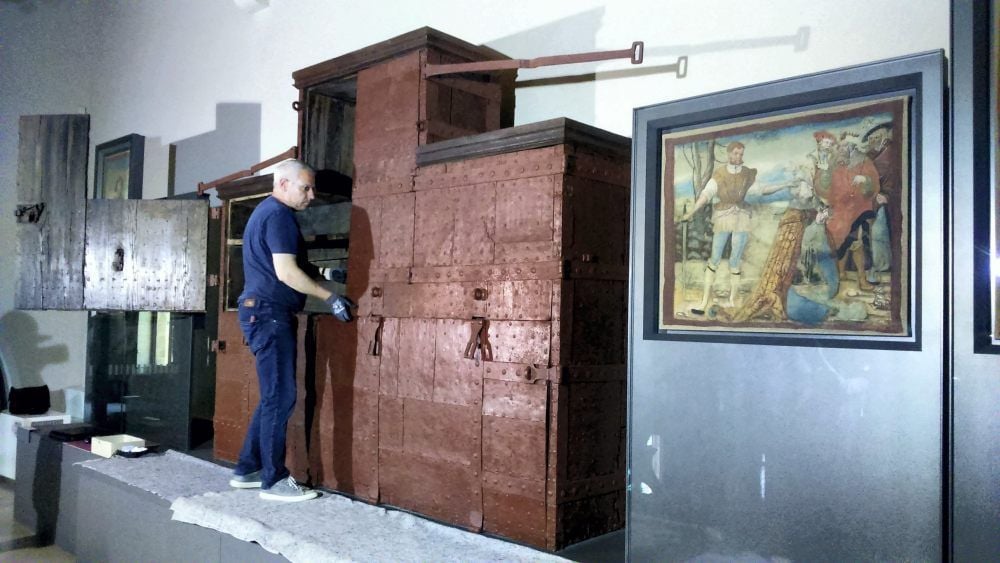 Restaurator Hartmut Meier öffnet den Heiltumsschrein im Halberstädter Domschatz. Das rechts präsentierte Gemälde war früher Teil des Schreins.