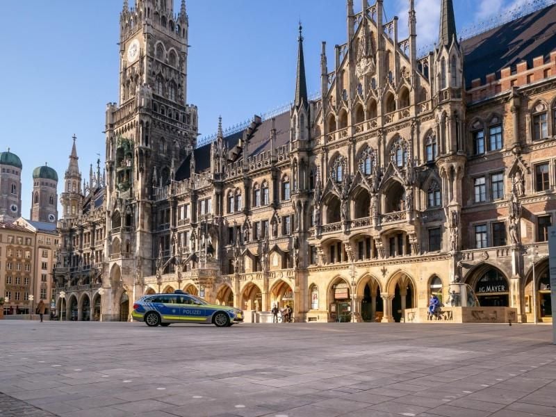 Ein Polizeiauto fährt über den fast leeren Marienplatz. Foto: Peter Kneffel/dpa