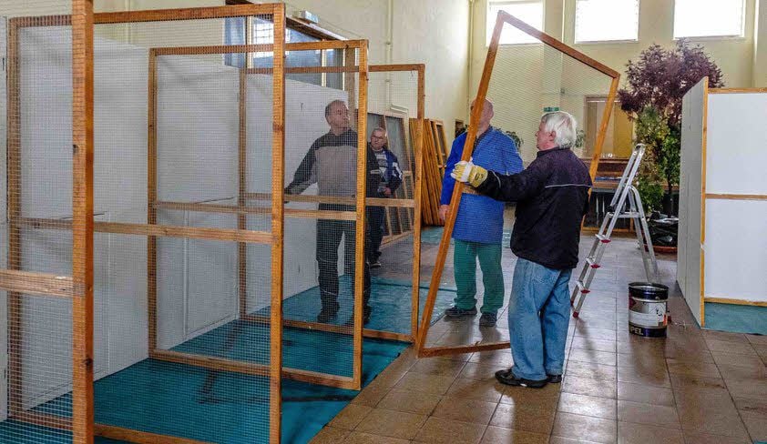 Die Vereinsmitglieder bauen die Volieren auf.