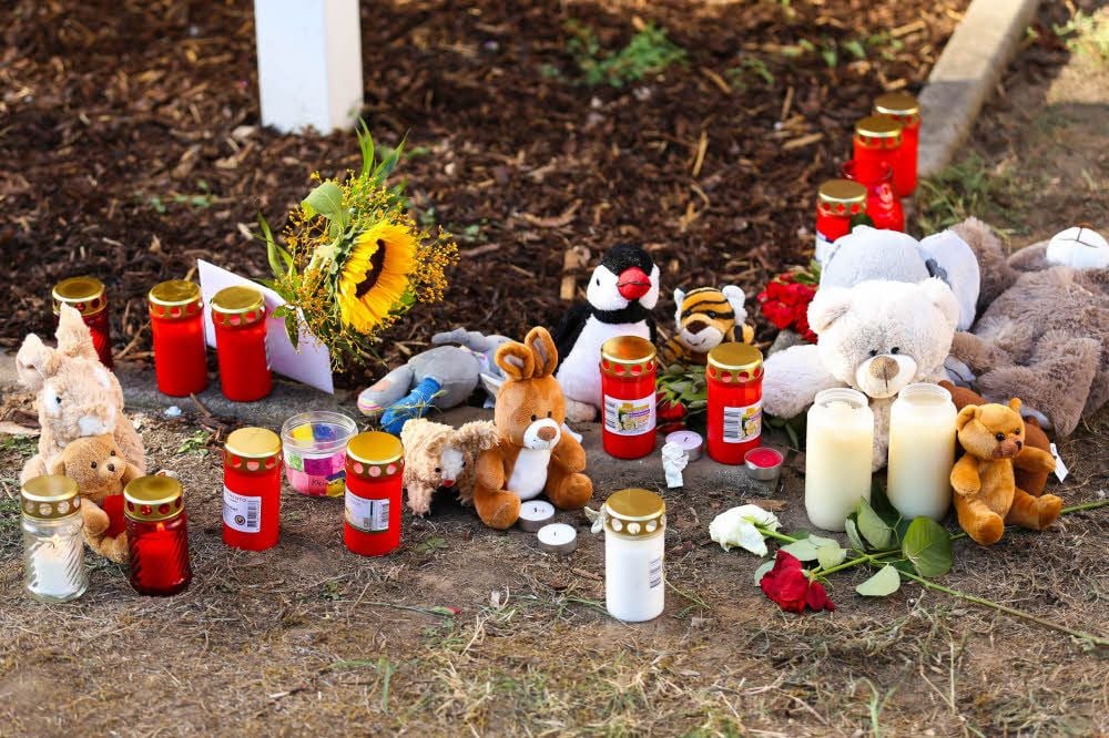 Dort wo der kleine Junge gestorben ist, haben Kinder und Erwachsene Kerzen aufgestellt. Neben Plüschtieren und Blumen sitzt ein kleiner Engel.