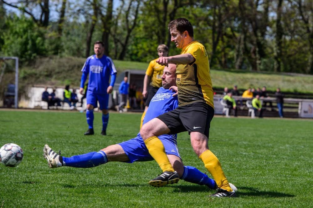 Florian Schlegel, der hier vor dem Mertendorfer Thomas Wichert (r.) grätscht, erzielte den dritten Treffer der Bad Kösener beim 3:0-Erfolg im Naumburger Stadion, der Ausweichspielstätte der Blau-Weißen.
