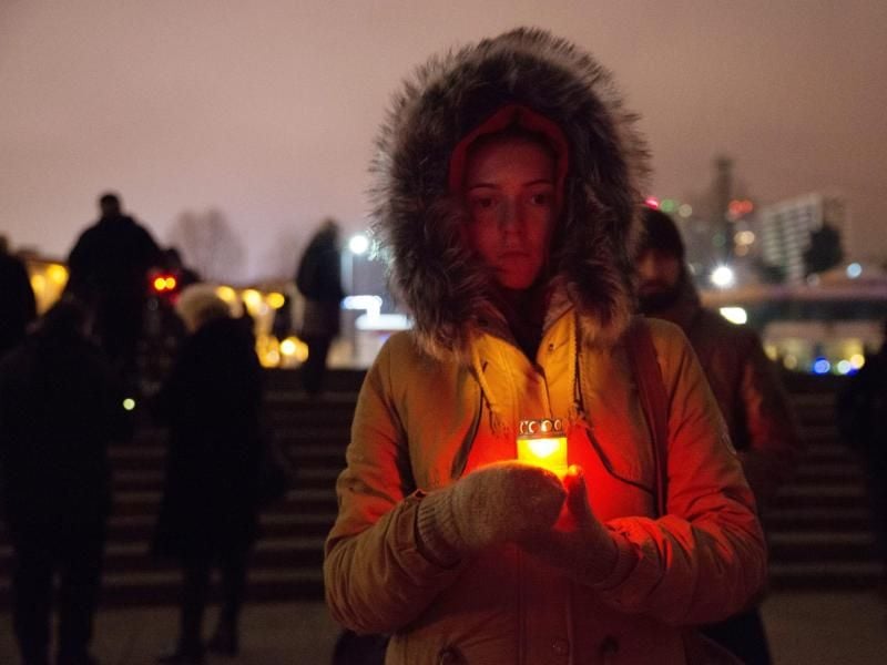 Trauer: Eine Russin hält zum Gedenken an die Absturzopfer der Militärmaschine Tu-154 eine brennende Kerze in den Händen. Foto: Yevgeny Reutov