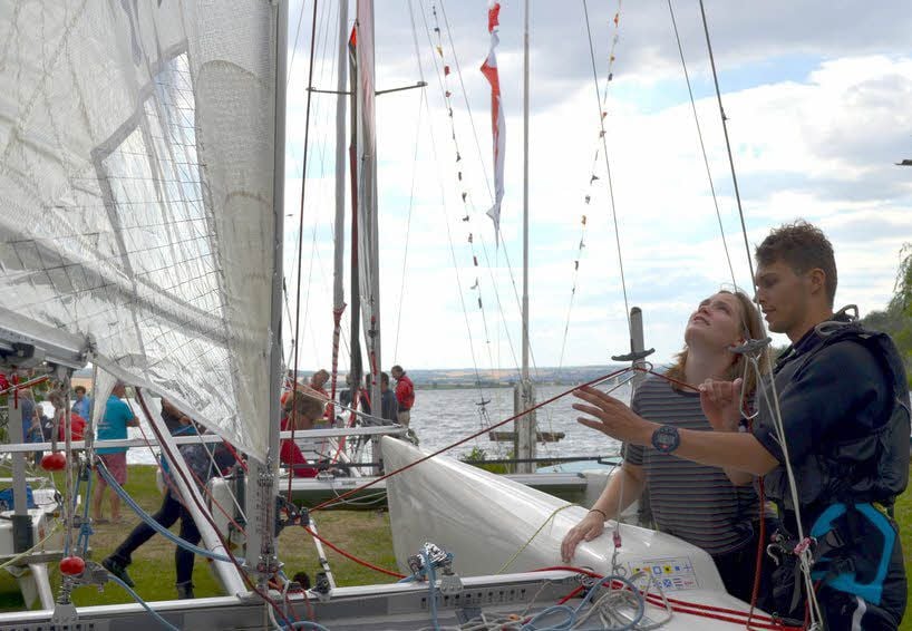 Wilhelm Rom und Alina Ludwig schauen nach zweimaligem Kentern nach, ob am Katamaran Schäden entstanden sind.