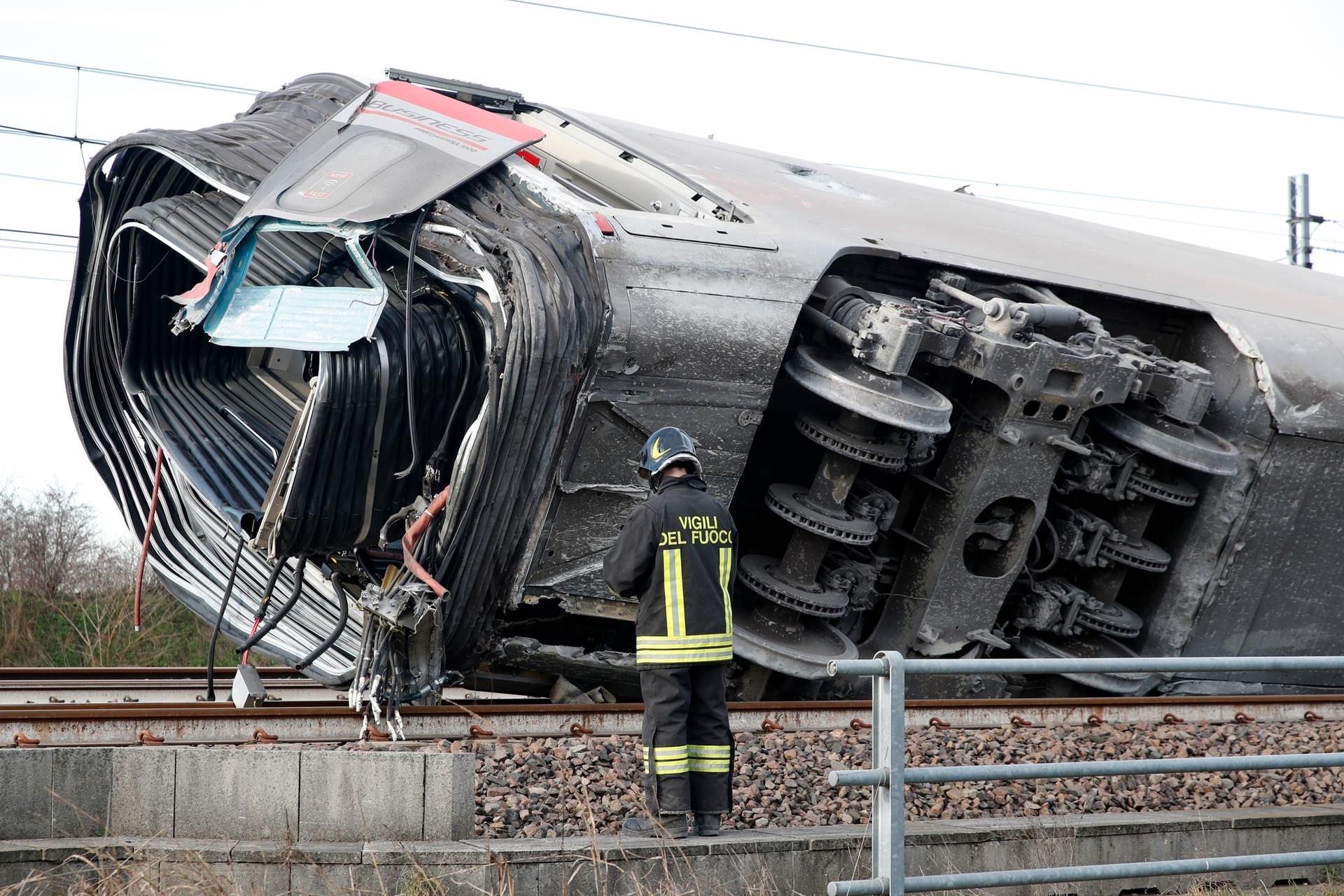 Ein Zugwaggon liegt umgekippt auf den Gleisen.