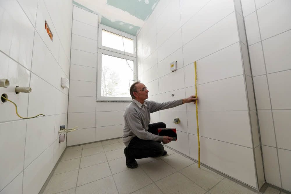 Fliesenleger Wolfgang Böttcher aus Dessau prüft die Fliesenarbeiten in der sogenannten Ritterburg in der Augustenstraße in Köthen.