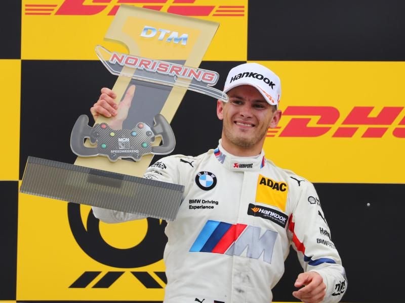 Marco Wittmann jubelt nach dem Rennen auf dem Podest mit der Trophäe über seinen ersten Platz. Foto: Daniel Karmann