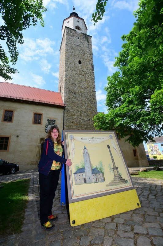 Vor dem Original: Sonja Quente am Aufsteller mit dem Lützener Schloss, der 2007 im Umzug mitgeführt wurde. Daneben ist die Günthersäule zu sehen. Auch die Rückseite zeigt Sehenswürdigkeiten der Stadt.