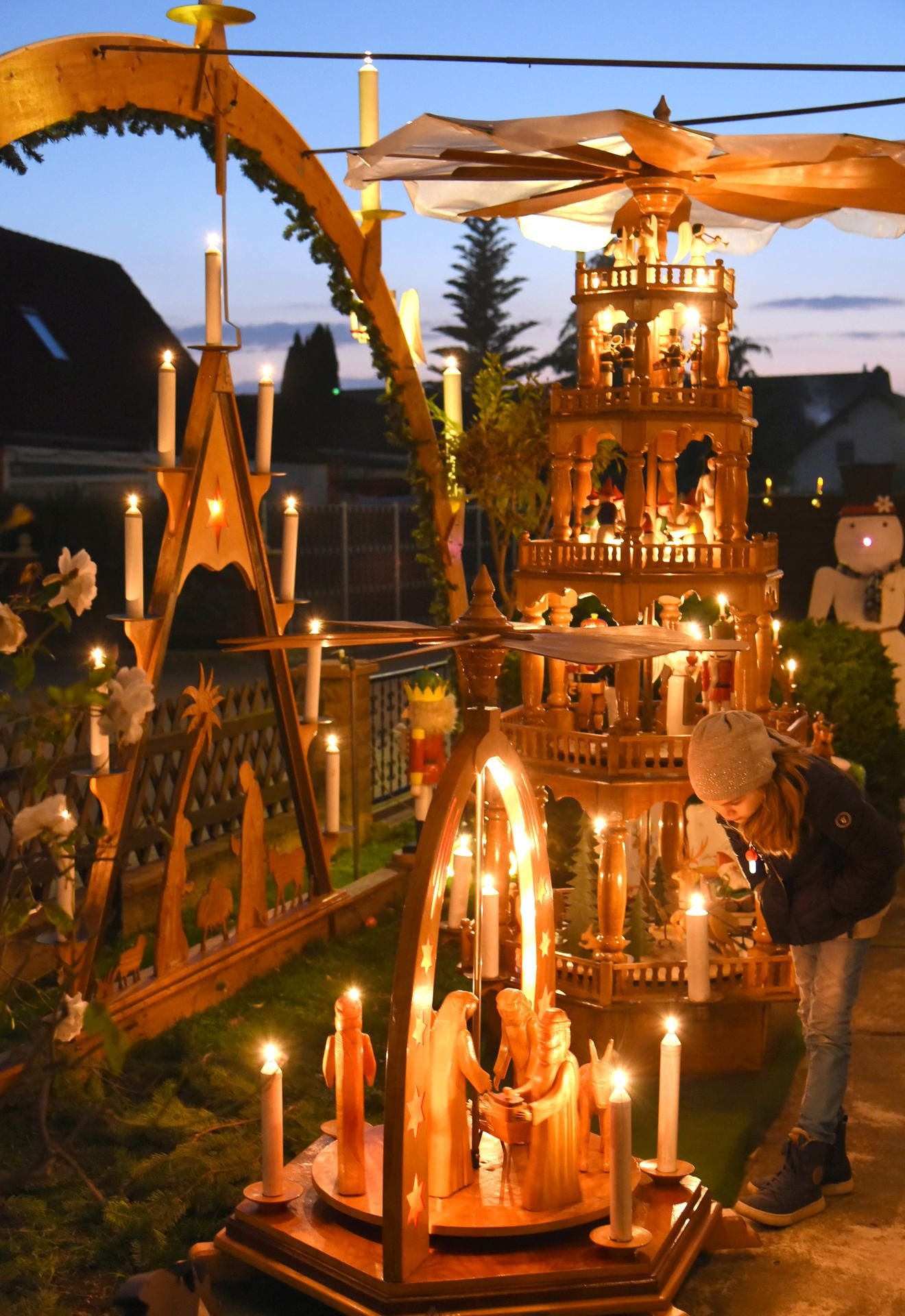 Ein Kind betrachtet im Vorgarten des 90-jährigen Rentners Herbert Thews sein eigenes kleines Weihnachtswunderland, das er sich in einer Siedlung am Stadtrand von Merseburg geschaffen hat.