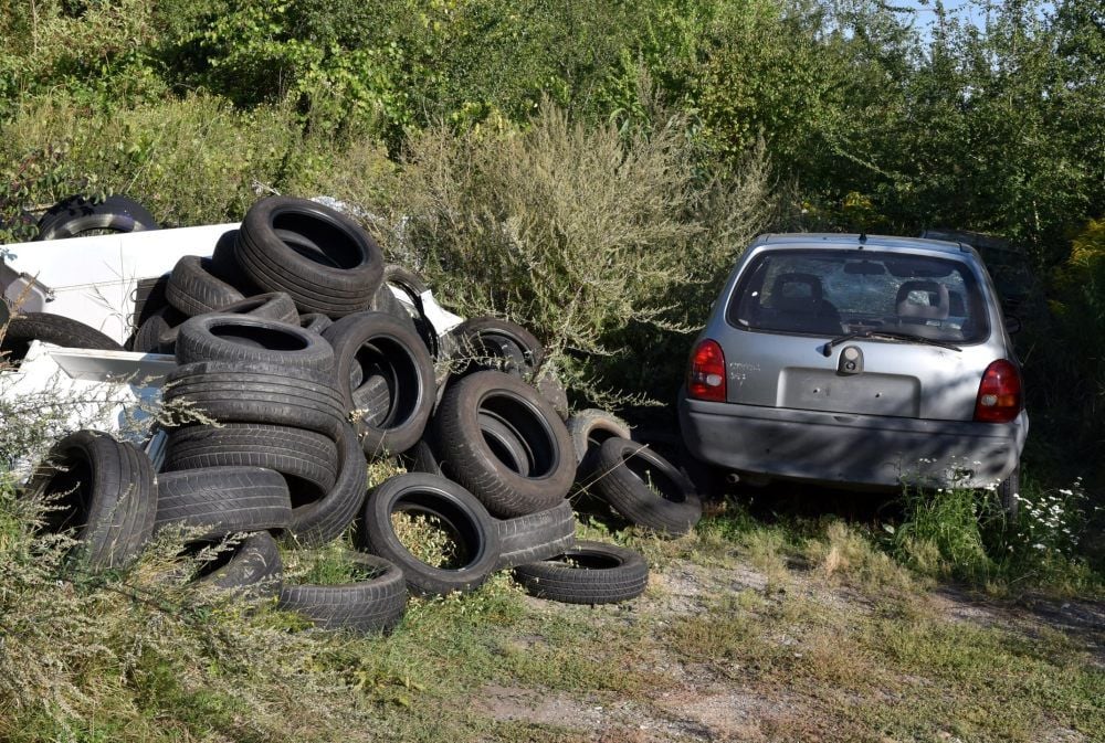 Altreifen und schrottreife Autos lagern auf dem ehemaligen Betriebsgelände der Quarzitgrube in Großkorbetha.