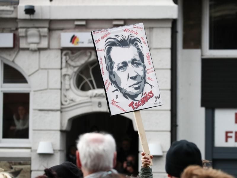 Ein Fan von Jan Fedder hält vor der Trauerfeier für den Schauspieler im Michel ein Plakat hoch. Foto: Christian Charisius/dpa