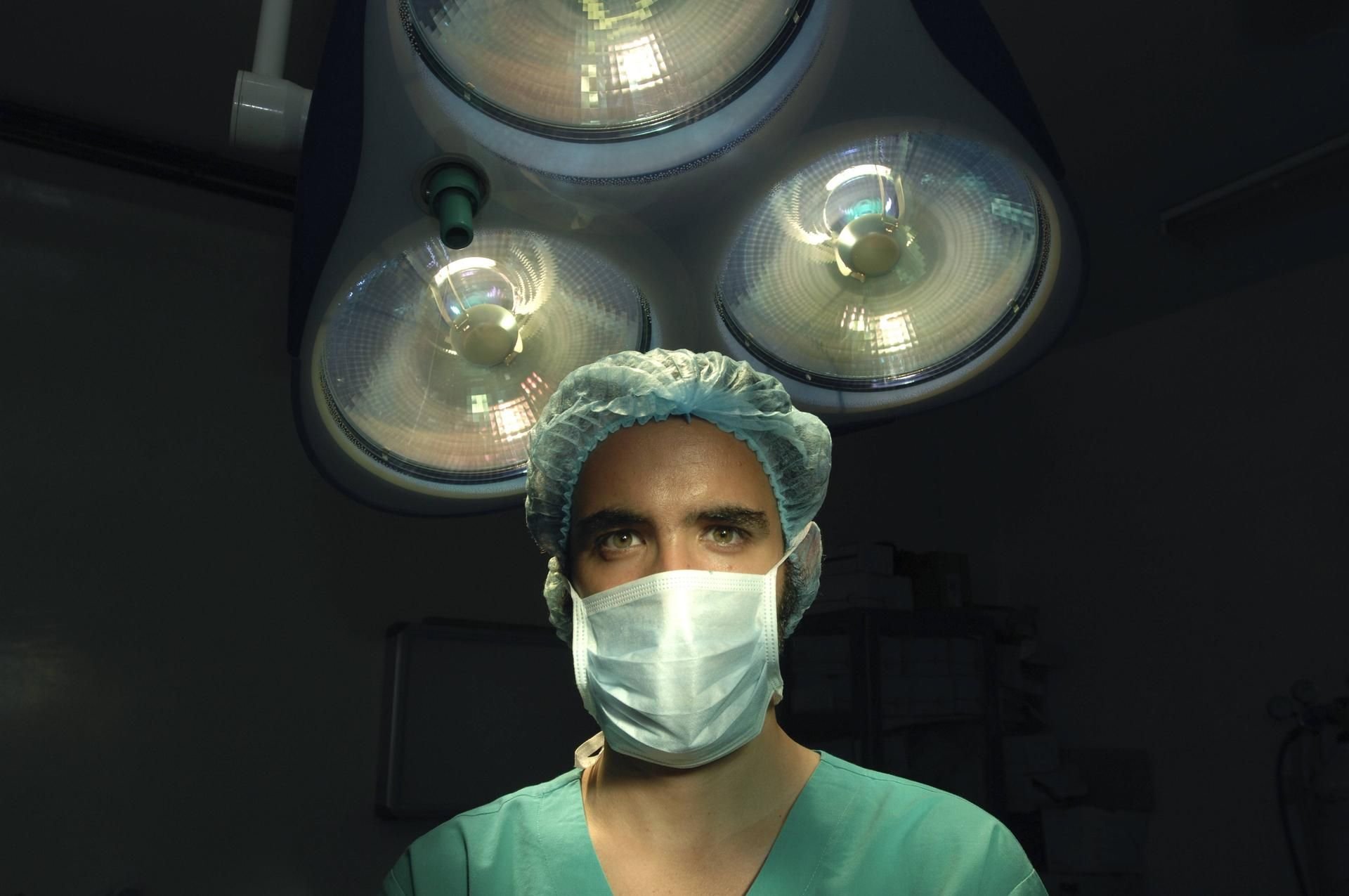 Eine Medizinerin steht mit Mundschutz in einem Operationssaal