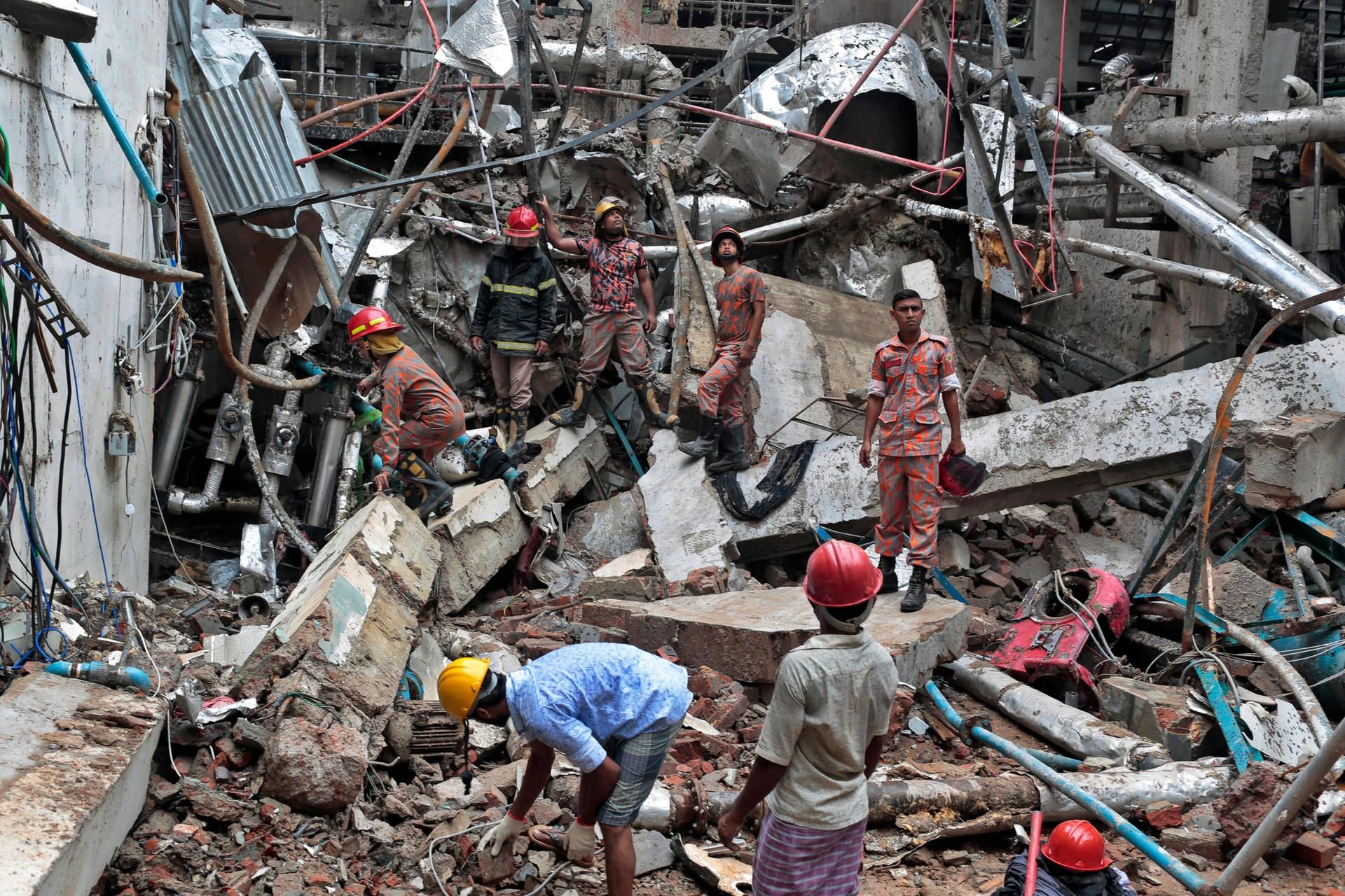 Feuerwehrleute und Rettungshelfer durchsuchen in Dhaka die Trümmer der Kleidungsfabrik, in der ein Boiler explodierte.