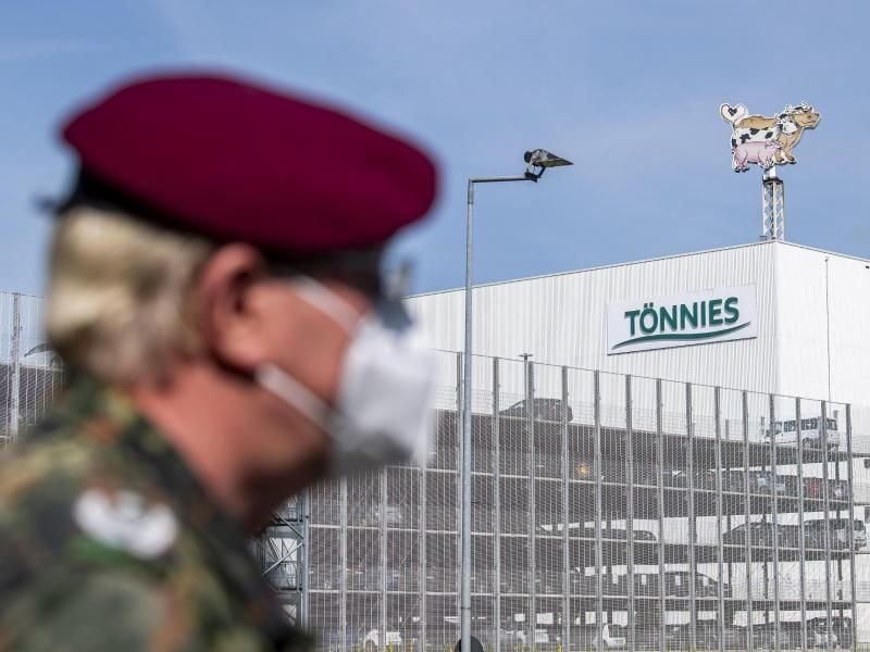 Ein Soldat Bundeswehr vor dem Gebäude der Fleischfabrik Tönnies in Rheda-Wiedenbrück. Foto: David Inderlied/dpa