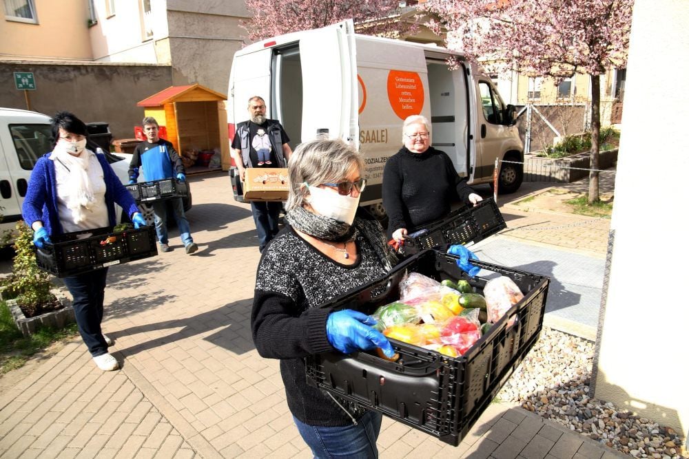 Die ehrenamtlichen Helfer tragen die Kisten voller Lebensmittel in die Räume der Bernburger Tafel.