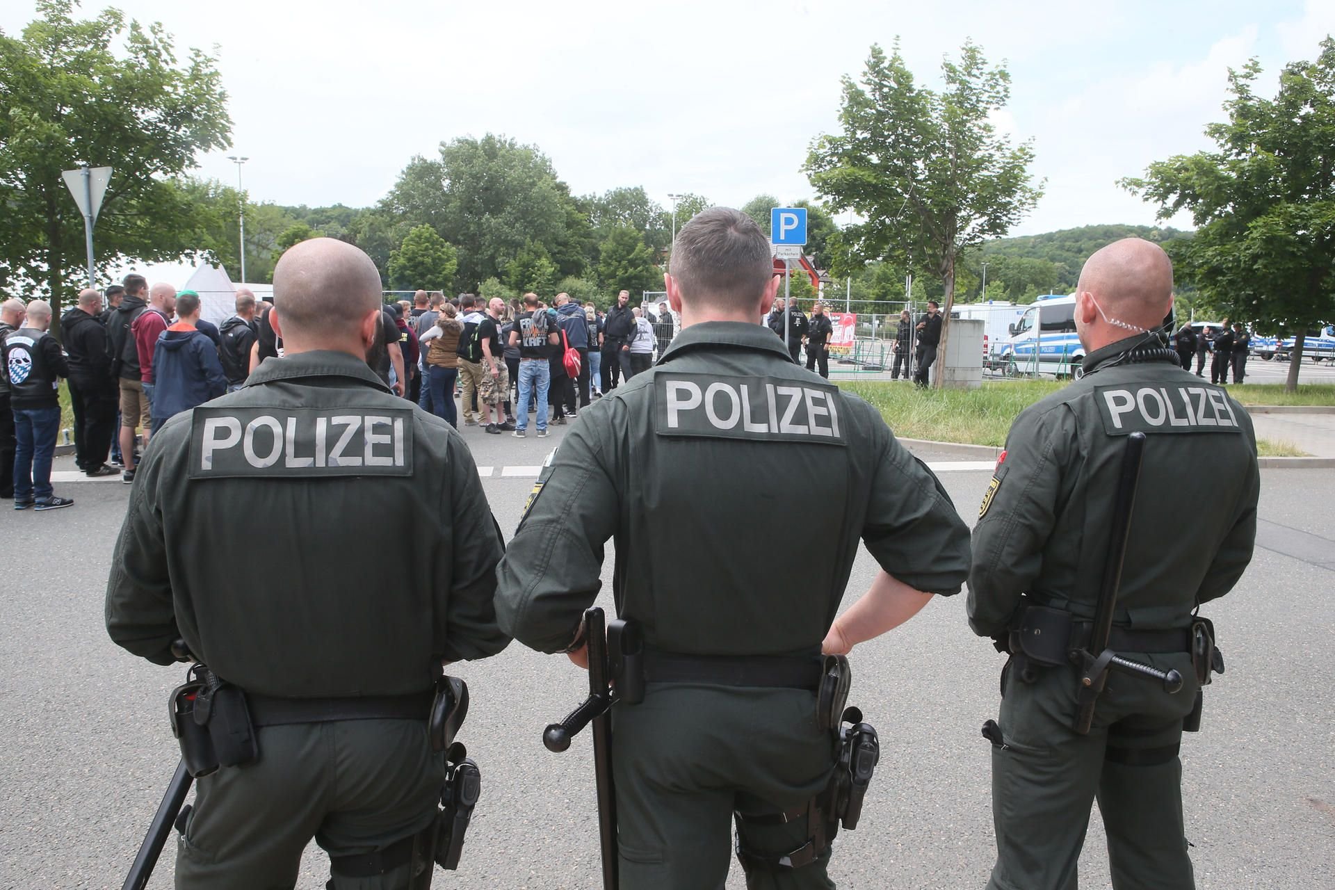 Gera: Polizeibeamte und Teilnehmer des RechtsRock-Festivals «Rock für Deutschland» stehen auf dem Veranstaltungsplatz.