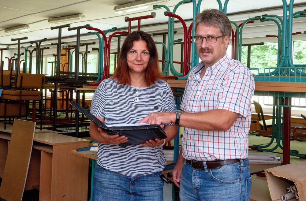 Doreen Jacob und Thomas Mahler von der Kreisverwaltung stehen hier in der Turnhalle, die als Zwischenlager für Schulmöbel diente.