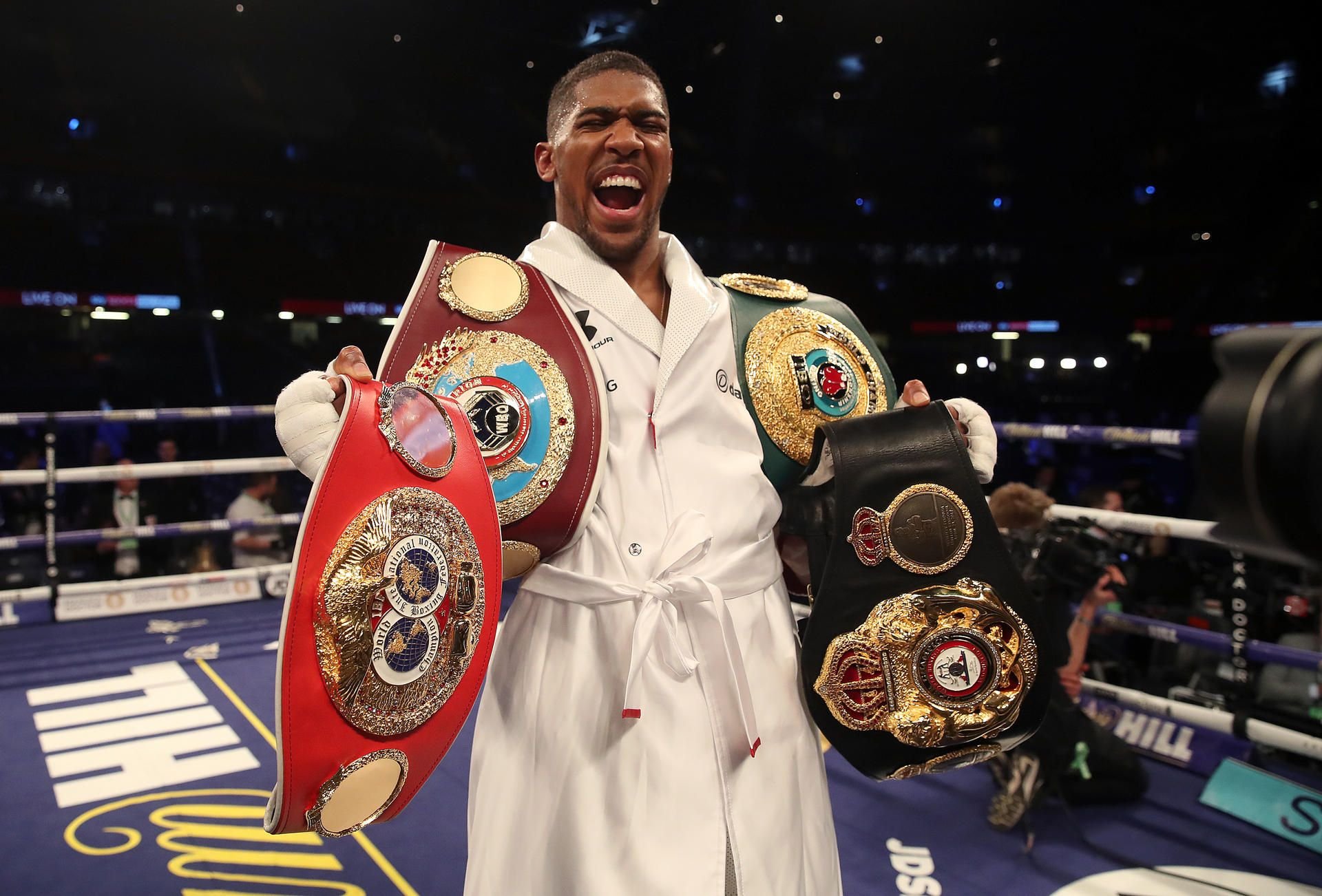 Anthony Joshua jubelt nach dem gewonnenen Kampf mit den Gürteln der vier Boxverbände WBA, IBF, IBO und WBO.