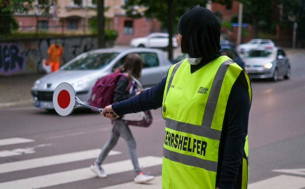 Satcita Gekhaeva sorgt als Verkehrshelferin in der Willy-Brandt-Straße mit roter Kelle und aufmerksamem Blick für einen sicheren Schulweg.