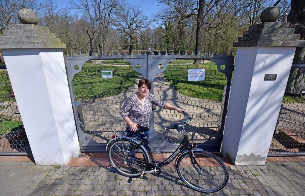 Gudrun Dietsch vor dem Gutspark in Altjeßnitz, dessen Tor sich in diesem Jahr noch gar nicht für Besucher geöffnet hat.