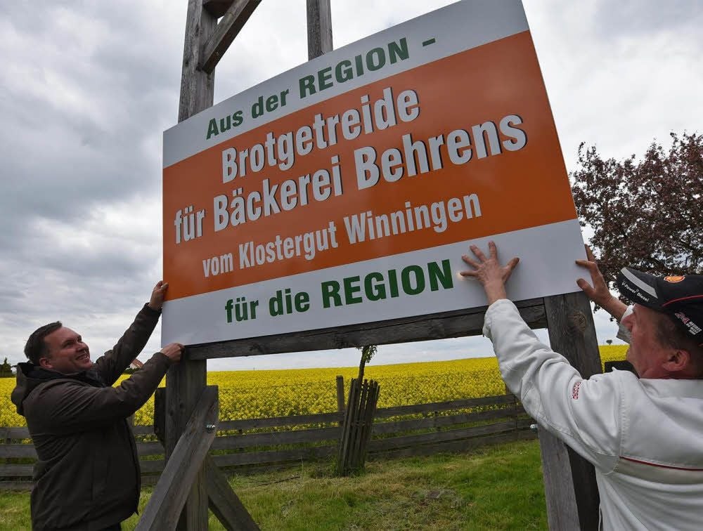 Arthur Strudel und Hartwig Behrens bringen das Schild an.