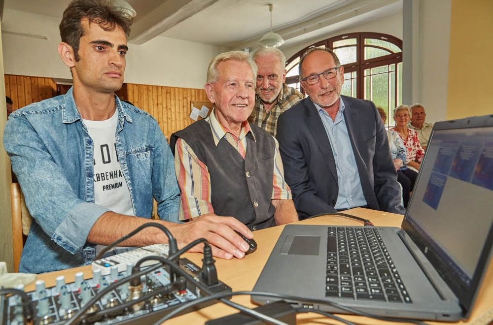 Mohsem Karinpour (von links) zeigt Winfried Wolter, Jürgen Nettling und Henry Schütze die zweisprachigen Bibelverse auf dem Laptop.