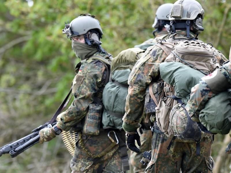 Fallschirmjäger des Kommando Spezialkräfte (KSK) bereiten sich in der Nähe von Ahrenviölfeld nach ihrem Absprung auf den Einsatz vor. Foto: picture alliance / Carsten Rehder/dpa