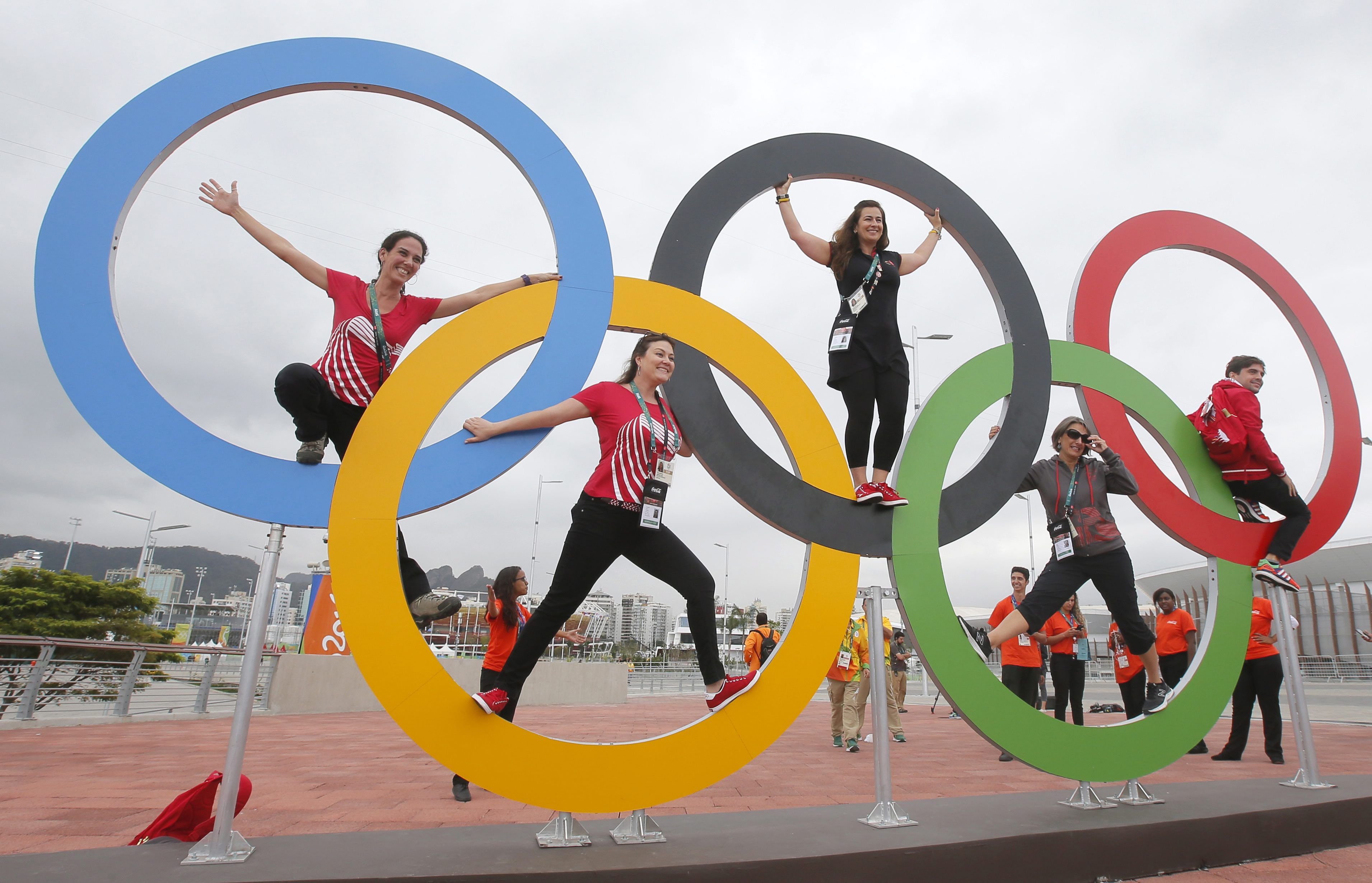 Menschen posieren in den Olympischen Ringen im Olympia-Park in Rio.