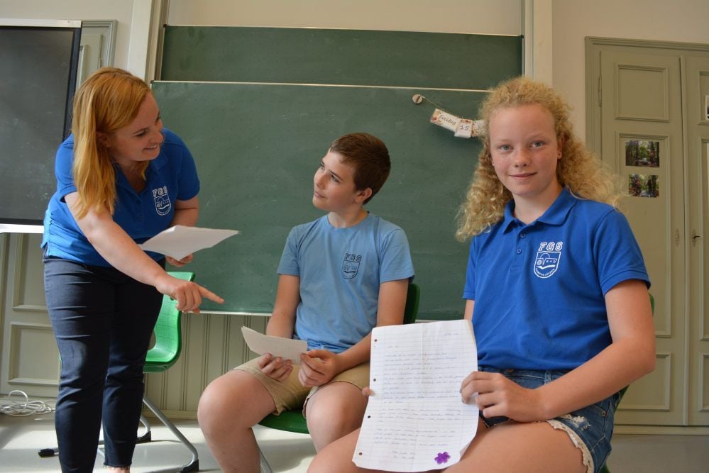 Lehrerin Paula Berger mit den Fünftklässlern Jonah und Zoe, die per Post eine Rückantwort von Senioren erhalten haben.