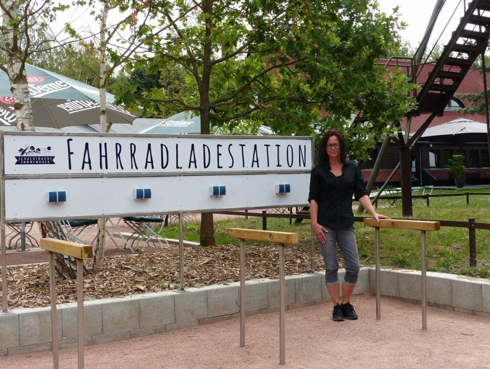 Die Chefin der Schachtbaude, Yvonne Willemsen, zeigt die Ladestationen für Elektrofahrräder.