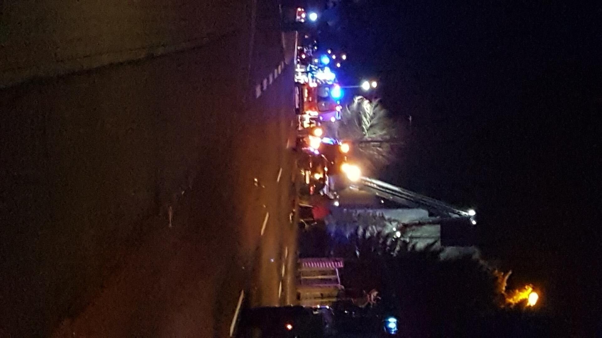 Feuerwehrleute steigen über den Balkon in das brennende Haus ein.