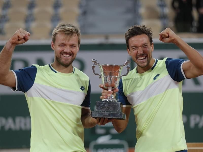 Freuen sich auf das Event in der Kölner Arena: Kevin Krawietz (l) und Andreas Mies feiern mit Trophäe den Finalsieg bei den French Open. Foto: Michel Euler/AP/dpa