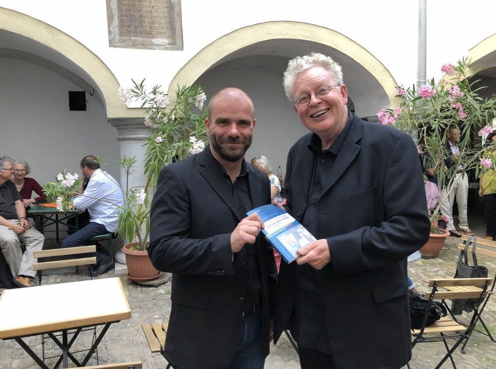 Rene Angelstein (links), einer der Herausgeber, überreicht die Festschrift an Professor Alfred Frei.