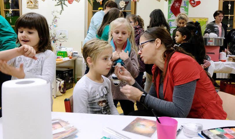 Yvonne Schlobach vom Förderverein der Annaburger Grundschule „Michael Stifel“ zaubert den Kindern kleine Gemälde ins Gesicht.