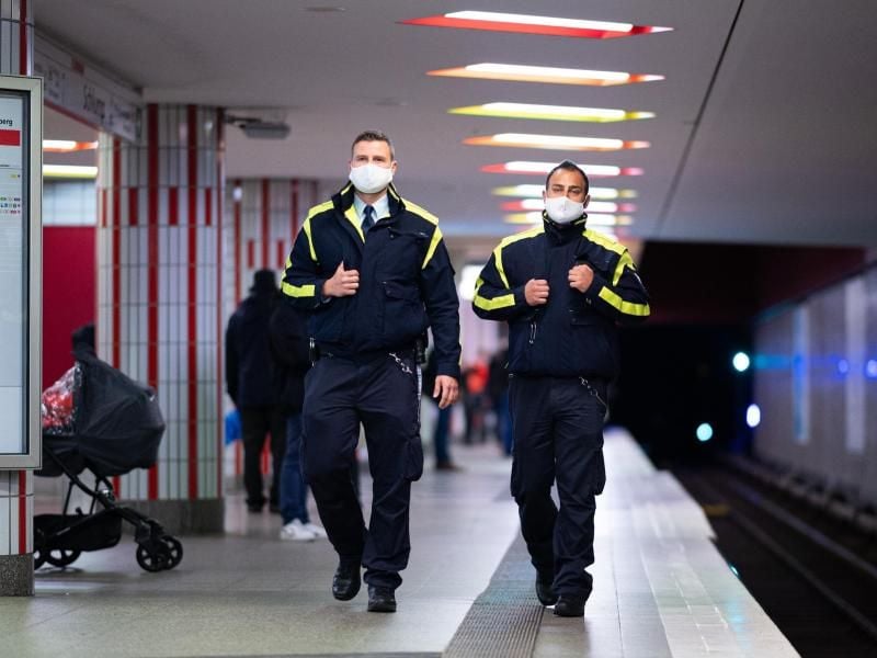 Mitarbeiter der Hamburger Hochbahn-Wache kontrolliert die Einhaltung der Maskenpflicht an einer U-Bahn-Haltestelle. Foto: Daniel Reinhardt/dpa/Archivbild