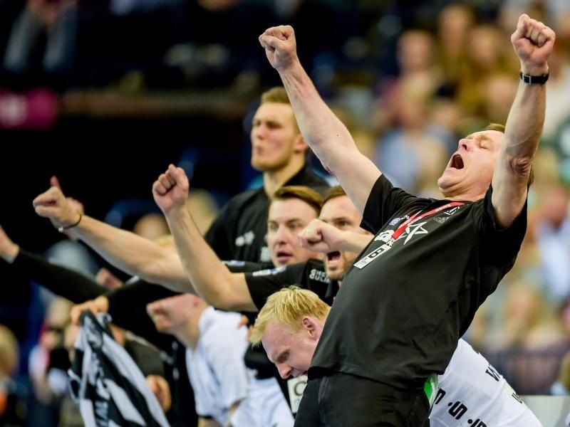 Kiels Trainer Alfred Gislason (r) jubelt gemeinsam mit seinen Spielern. Foto: Axel Heimken