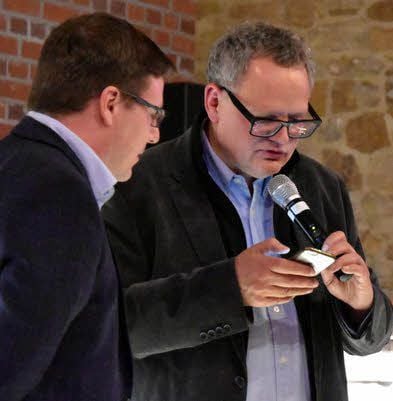 Ulli Potofski (rechts) sucht auf seinem Smartphone die Reportage des fiktiven Spiels Elsters E-Jugend gegen Bayern München, um sie Christian Zapkay vorzuspielen.