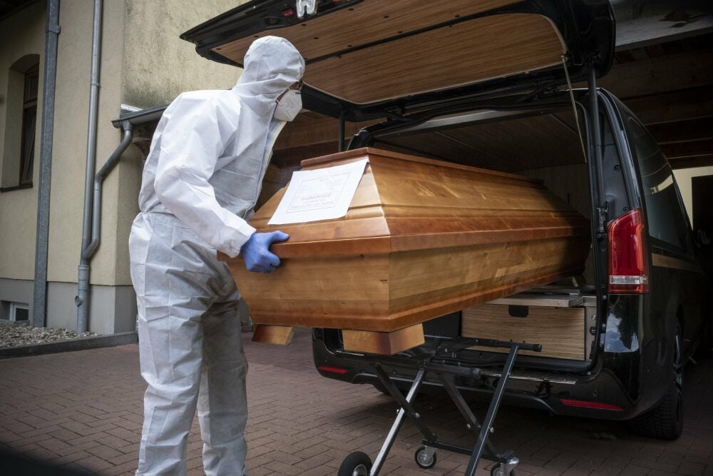 Stirbt ein Mensch, der mit dem Coronavirus infiziert ist, müssen sich die Bestatter beim Kontakt mit dem Toten mit besonderer Kleidung schützen.