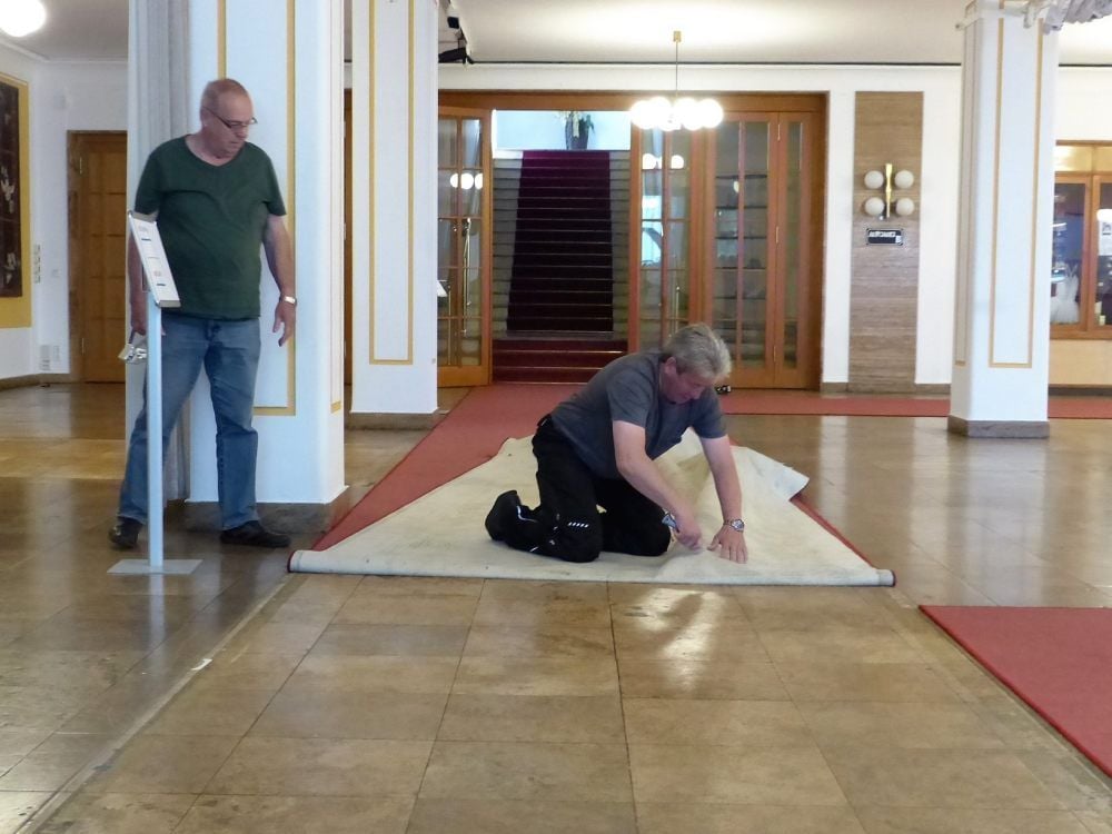 Mario Kunz und Heinz Theuer (v.r.) entfernen im Foyer des Wolfener Kulturhauses den alten, etwa 30 Jahre alten, Teppichboden.