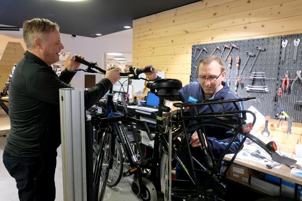 Intersport-Chef Karsten Klöpping (links) bespricht mit Mitarbeiter Ronny Pietlasky den Reparaturauftrag am Fahrrad.