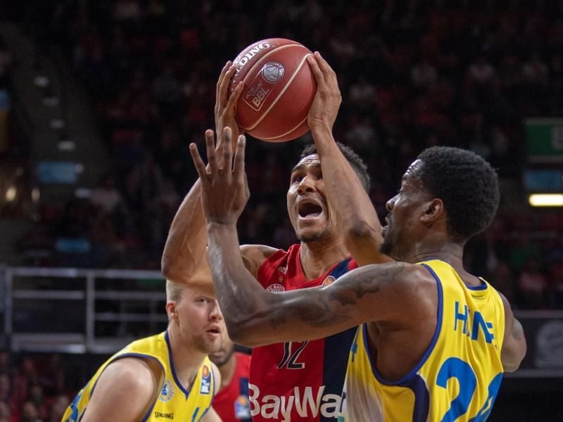 Braunschweigs Shaquille Hines (r) versucht Bayern-Profi Maodo Lo am Wurf zu hindern. Foto: Lino Mirgeler