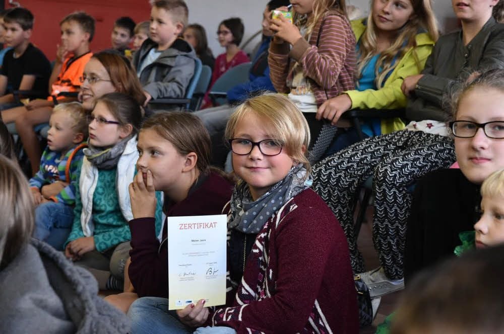 Laura Melzer zeigt ihr Zertifikat. Die Urkunden zum Abschluss des Lesesommers übergaben OB Bernward Küper und Fachbereichsleiter Armin Müller.