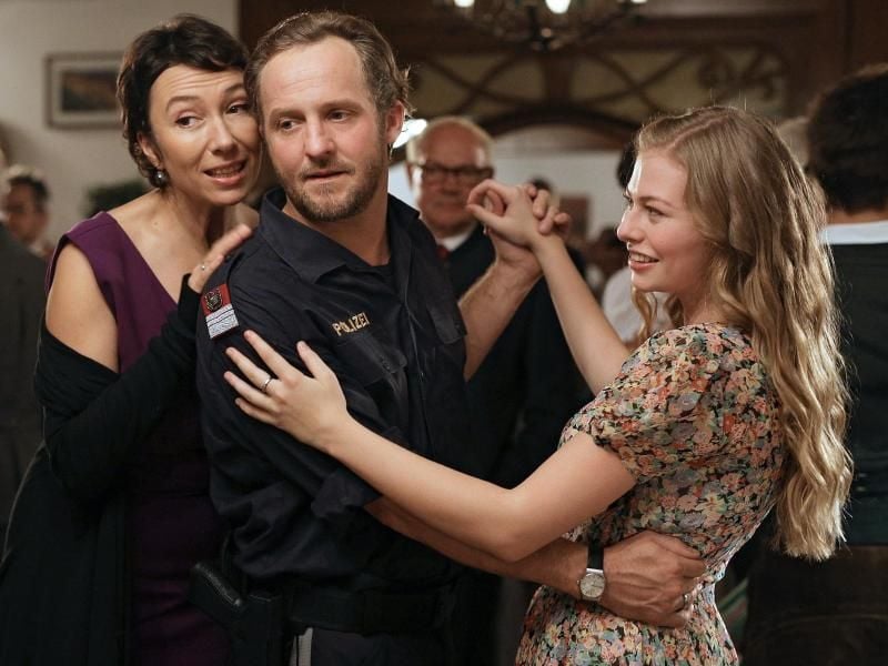 Da ist alles noch in Ordnung: Polizeiinspektor Hannes Bucher (Maximilian Brückner) feiert mit seiner 17-jährigen Nichte Rosa (Zoe Straub) und Ehefrau Maria (Ursula Strauss, l). Foto: ARD Degeto/Mona Film/Petro Domenigg