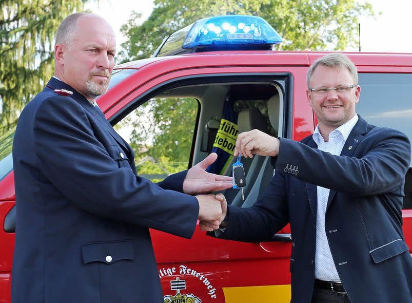 Bürgermeister Michael Knoppik (r.) übergibt dem Badeborner Ortswehrleiter Steffen Wolf die Schlüssel für den neuen VW T5.