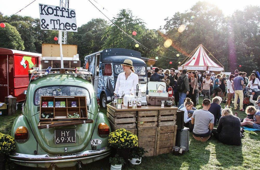 Rustikal und gesellig geht es auf dem Streetfood-Festival zu. Verkäufer bieten Speisen und Getränke an ihren teils mobilen Ständen an.
