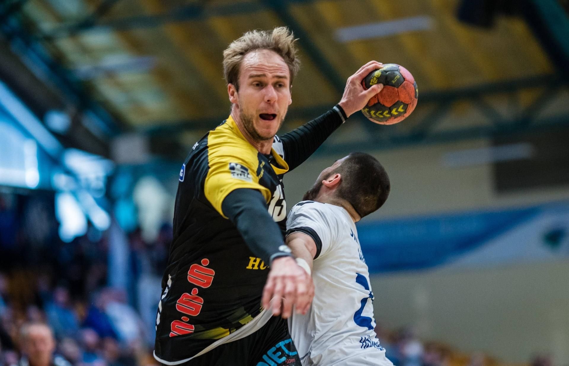 Stefan Lex (l.) vom HSC Coburg bei einem Wurf, den Jonas Hönicke vom Dessau-Rosslauer HV in der Anhalt Arena verhindern will.