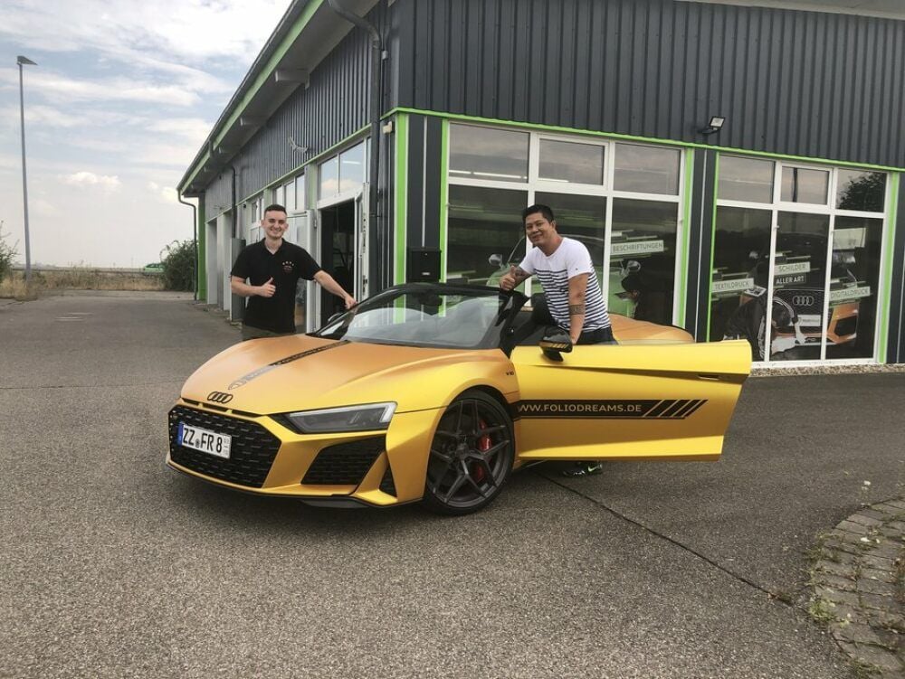 Echter Hingucker: Philipp Planstedt (l.) und Long Dam stehen mit einem mit goldfarbener Folie gestalteten Auto vor der neuen Werkstatt.