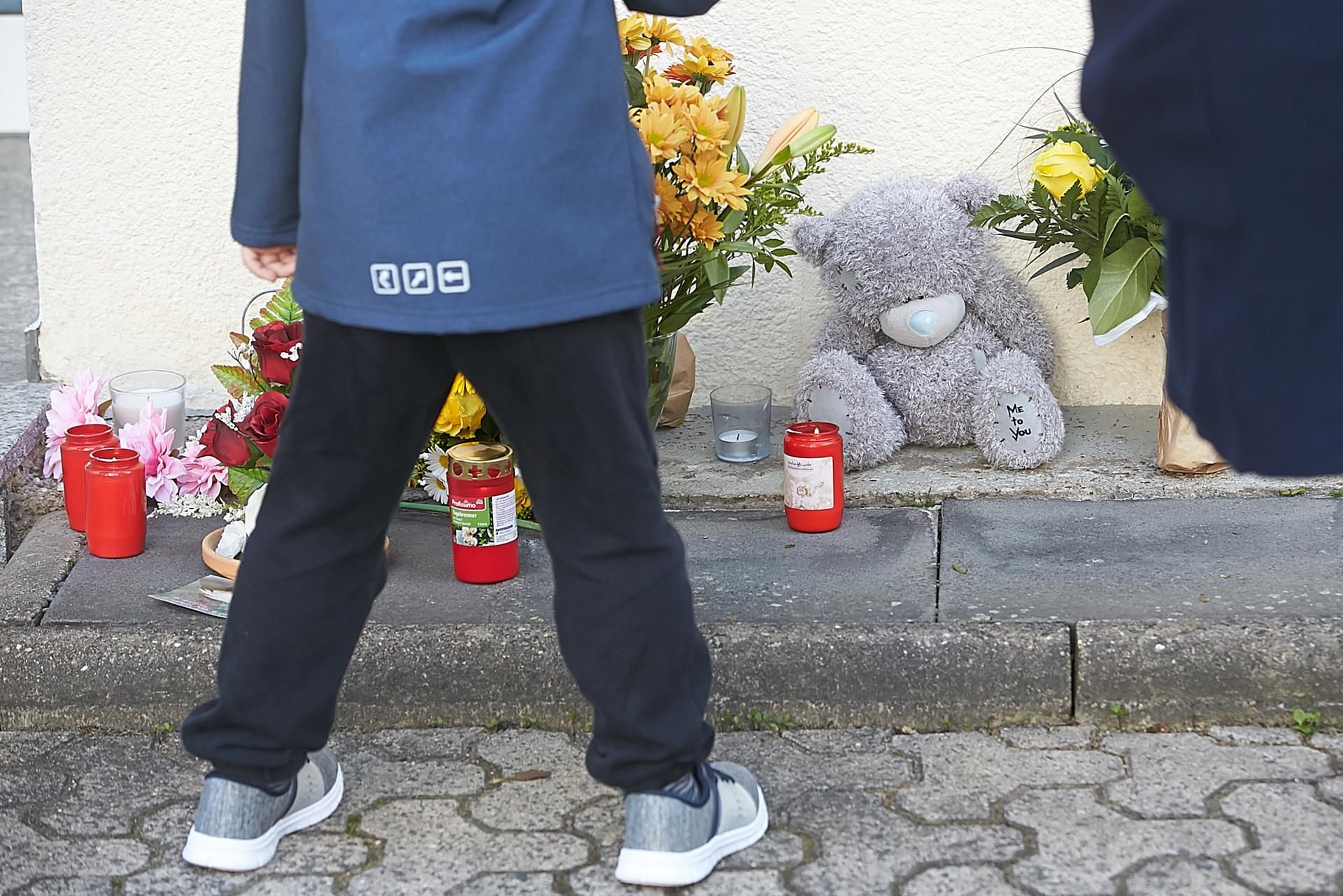 Ein Kind steht nach dem Unglück vor dem Kindergarten in Bad Breisig vor Trauerbekundungen.
