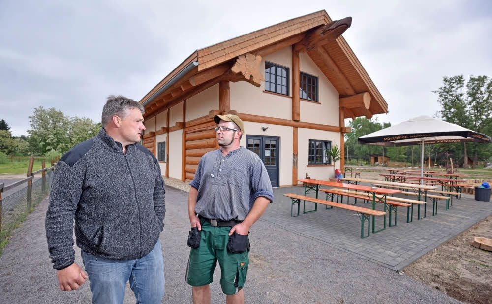 Blausee-Prokurist Carsten Helling (li.) und Fischer Markus Lingner stehen vor dem neuen Hofladen in der Nähe des Gröberner Sees.
